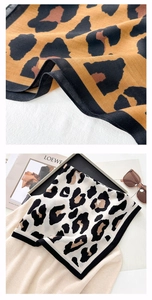 Macro detail of leopard print scarf showing twill texture and black stitched edges