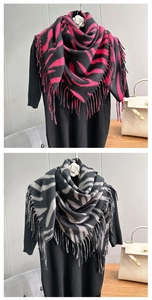 Detailed view of zebra print fringed scarves in magenta and grey knit material