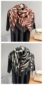 Detail of zebra pattern cashmere-like scarf showing thick knit texture and long fringe