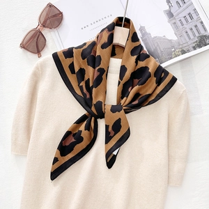 Classic leopard print silk wool scarf styled with beige knit top and chic sunglasses