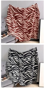 Detail of zebra pattern cashmere-like scarves with fringe edges in two colors