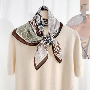 Foulard élégant en soie à chevrons et imprimé floral noué sur un haut en maille beige