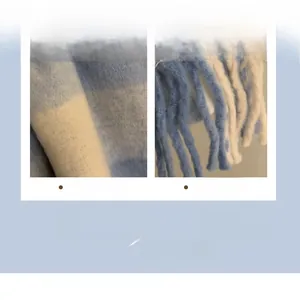 Detail of blue and white plaid scarf featuring soft knit fabric and long tassel edges
