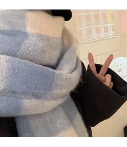 Detail shot of the blue and white checkered thick scarf on a black coat outfit