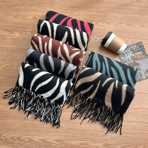 Zebra print cashmere-like scarves in multiple colors with tassels on wooden background