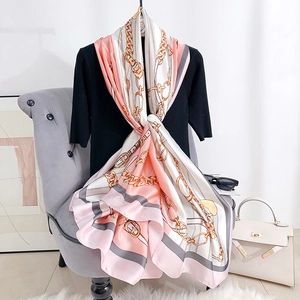 Eleganter Seidenschal mit rosa Kettenmuster auf Schaufensterpuppe mit Kelly-Tasche-Deko