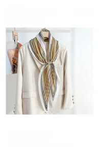 Close-up of diamond-shaped silk scarf with creative stripes on a beige blazer