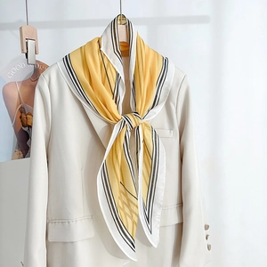 Elegant diamond silk scarf with artistic yellow line prints over a beige office suit blazer