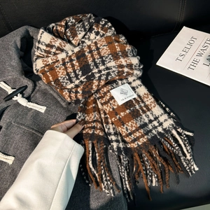 Classic thick plaid scarf in brown and beige with fringe details on a wool coat