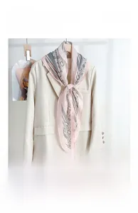 Detail of pink and grey geometric diamond silk scarf draped on a modern blazer jacket