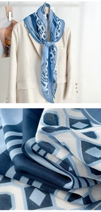 Detailed view of blue geometric silk scarf fabric texture on a beige suit blazer