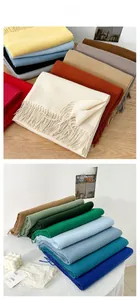 Close-up of soft cashmere-feel scarves with fringe detail in multiple solid colors