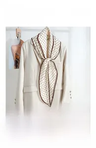 Close-up of diamond-shaped polka dot neck scarf paired with a beige blazer jacket
