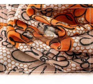 Close-up of mercerized wool scarf featuring orange and black patterns with a honeycomb texture