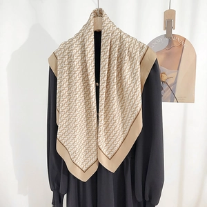 Vintage silk-like scarf with V-pattern print and contrast borders on a black dress