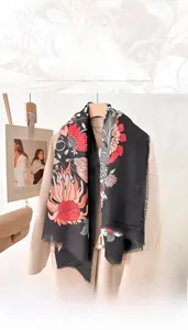 Detail of printed large square scarf with red floral patterns and fringed edges
