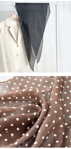 Detailed view of polka dot silk scarf texture and elegant blazer styling ensemble