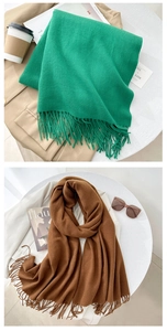 Detail of soft cashmere-like scarf with long fringe in vibrant green and brown tones