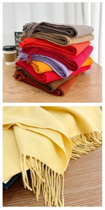 Macro shot of soft cashmere-like fabric textures and delicate tassels on winter scarves