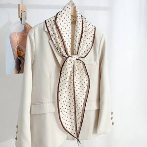 Polka dot faux silk scarf in beige with dark brown accents on an elegant blazer