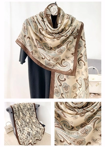 Detail of beige cotton-linen scarf with brown paisley patterns and wide stitched borders