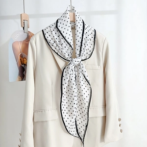 Elegant polka dot silk scarf for women tied on a beige blazer for a stylish office look