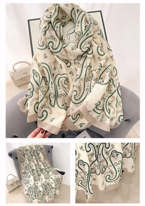 Detail showing the intricate paisley patterns and soft woven texture of the shawl