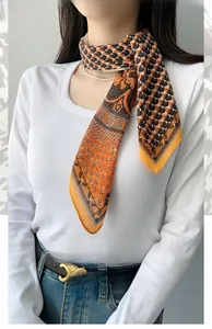 Detail of orange herringbone square scarf styled elegantly on a professional model's neck