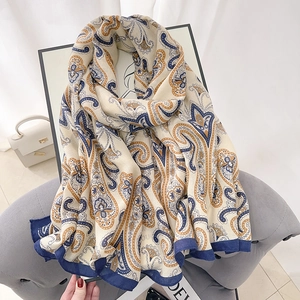 Elegant cotton linen scarf with blue and yellow paisley print on a soft beige background
