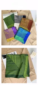 Close-up of elegant satin square scarf featuring geometric stripe patterns and vibrant colors