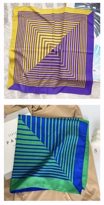 Detail view of geometric silk scarves with colorful contrast stripes and satin finish
