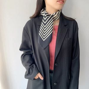 Elegant black and white striped silk square scarf worn by a model in a modern suit