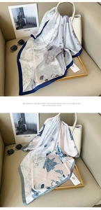 Detail of elegant silk scarves featuring floral prints and sophisticated contrast borders