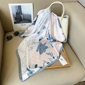 Elegant rose floral print silk square scarf styled on a white leather designer handbag