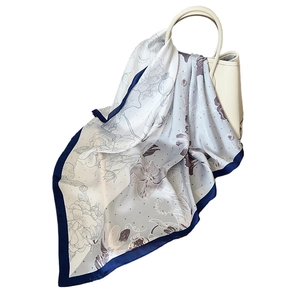 Elegant rose floral silk scarf tied on a white handbag with vintage polka dot pattern