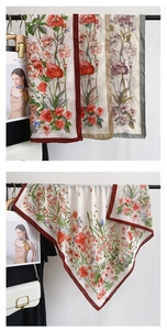Detailed close-up of floral print silk scarves with contrast border and satin finish
