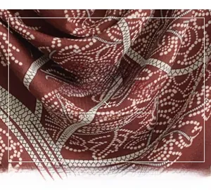Detailed close-up of ethnic patterned mercerized wool scarf in reddish brown tones
