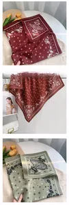 Detail of satin square scarf with paisley and star print in burgundy and green tones