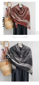 Detail view of mercerized wool scarf in burgundy and black with tassel edges and tree pattern