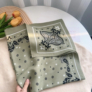 Sage green paisley square scarf with star pattern displayed with yellow tulips