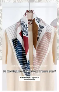 Detail view of herringbone pattern silk-like scarf on a knitted beige sweater