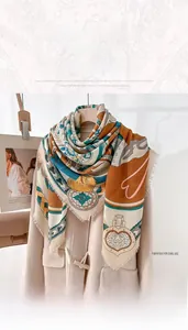 Detailed view of the 130cm printed square scarf styled on a beige cashmere coat