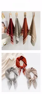 Detailed view of silk-like geometric pattern scarves in burgundy and sage green colors