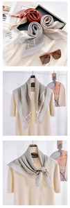 Detail of silk-like scarf featuring classic white rope patterns and geometric borders