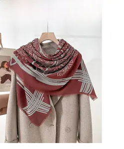 Detail of burgundy mercerized wool scarf with ethnic patterns and loose whisker fringes