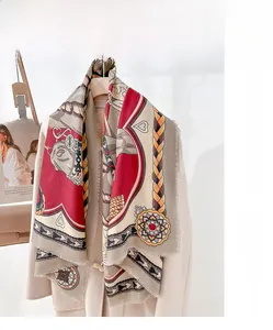 Detail of silk wool pashmina scarf with horse motifs and fringes on a beige coat