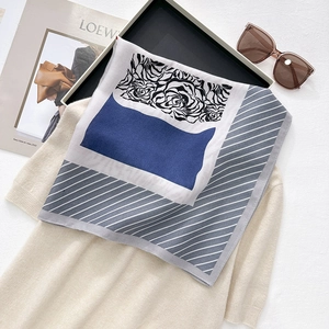 Silk-like square scarf featuring floral patterns and navy stripes on a beige knit top