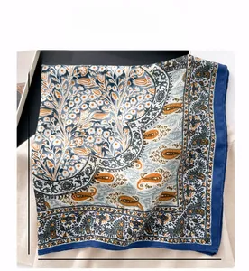 Macro detail of a 68cm square silk scarf with floral paisley patterns and smooth texture