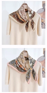 Detail of vintage paisley floral silk scarves tied on a beige knit sweater collar