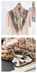Detail view of paisley floral silk scarf with retro patterns and soft cream border